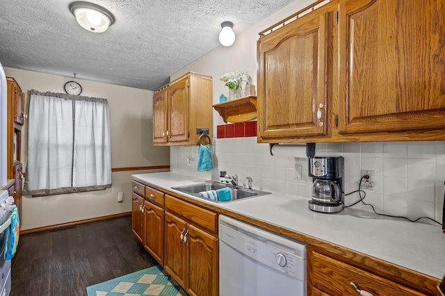 kitchen featuring dishwasher, sink, dark hardwood / wood-style flooring, backsplash, and a textured ceiling