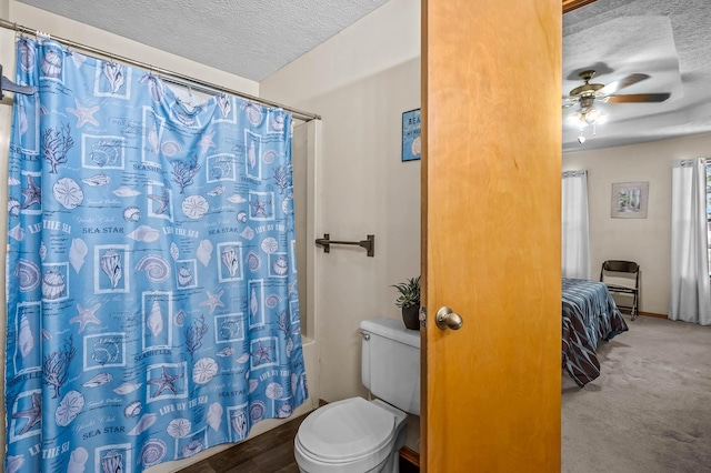 bathroom featuring ceiling fan, walk in shower, hardwood / wood-style floors, a textured ceiling, and toilet