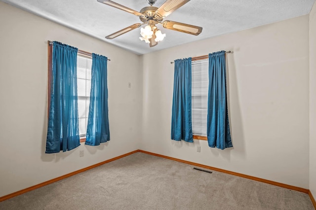 carpeted empty room featuring ceiling fan and a textured ceiling