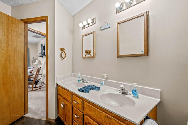 bathroom featuring hardwood / wood-style flooring, vanity, and a textured ceiling