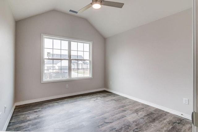 spare room featuring dark hardwood / wood-style floors, vaulted ceiling, and ceiling fan