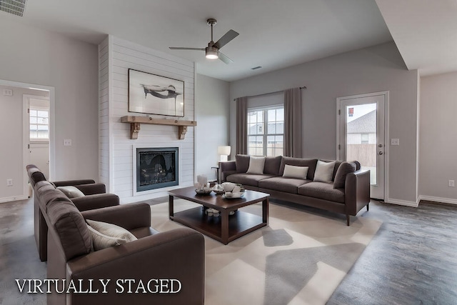 living room featuring ceiling fan and a fireplace