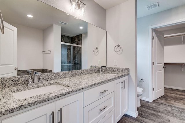 bathroom with vanity, toilet, walk in shower, and hardwood / wood-style flooring