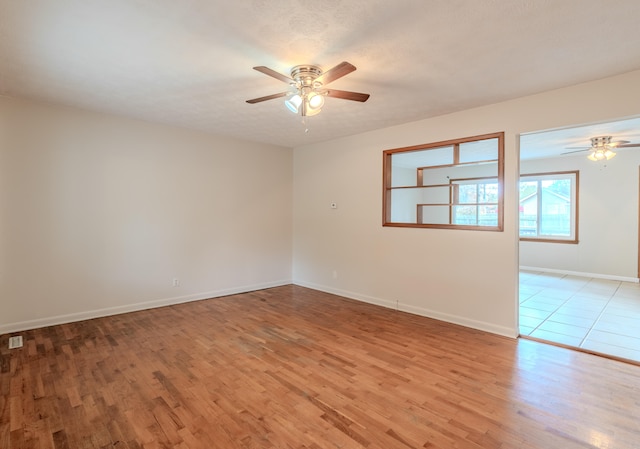 spare room featuring light hardwood / wood-style flooring, a textured ceiling, and ceiling fan