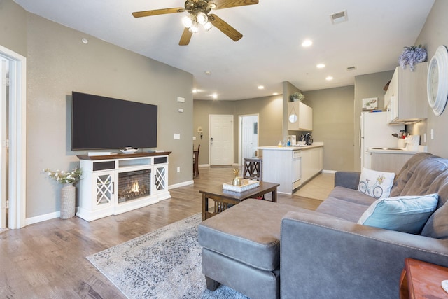 living room with light hardwood / wood-style floors and ceiling fan