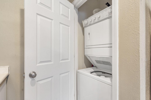 clothes washing area with stacked washer / dryer