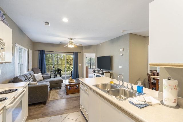 kitchen with white appliances, sink, light wood-type flooring, ceiling fan, and white cabinets