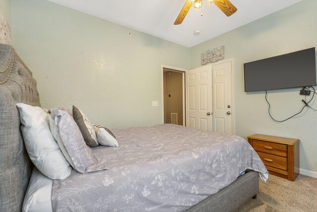 carpeted bedroom featuring a closet and ceiling fan