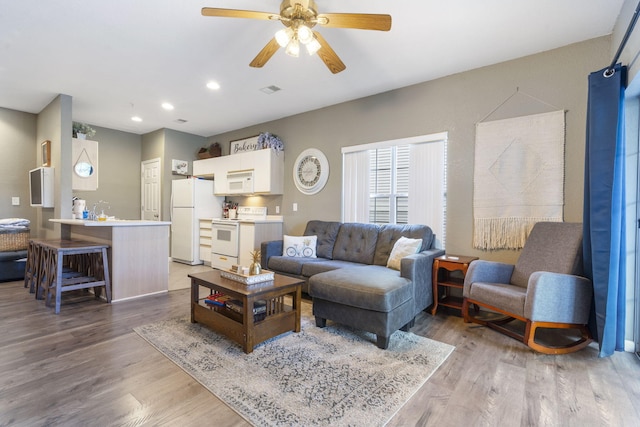 living room featuring wood-type flooring and ceiling fan