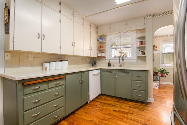 kitchen with sink, tasteful backsplash, a wealth of natural light, and light wood-type flooring