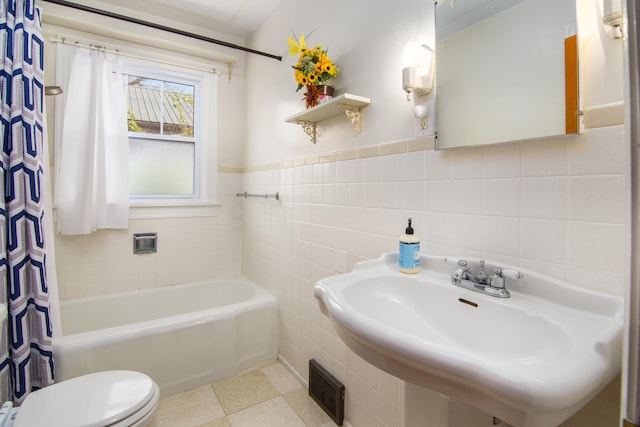 full bathroom featuring tile walls, sink, shower / tub combo with curtain, and toilet