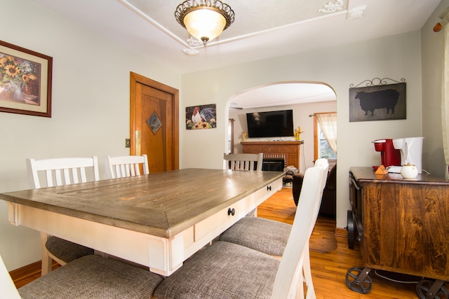 dining space featuring hardwood / wood-style flooring and a fireplace