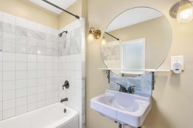 bathroom with tiled shower / bath combo and sink