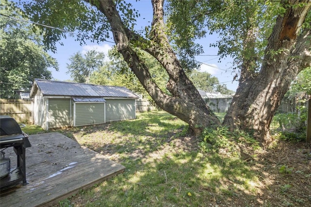 view of yard featuring a storage unit and a wooden deck