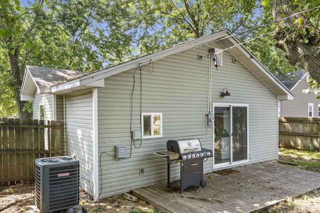 rear view of property featuring a wooden deck and central AC unit