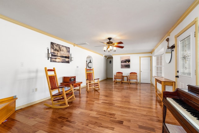 sitting room with crown molding, hardwood / wood-style flooring, and ceiling fan