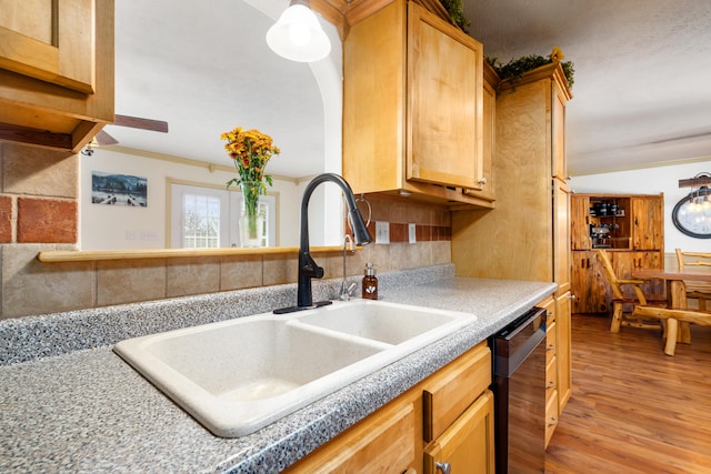 kitchen with black dishwasher, ornamental molding, sink, and light hardwood / wood-style floors