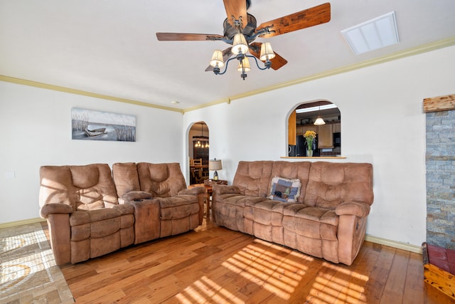 living room with hardwood / wood-style floors, crown molding, and ceiling fan