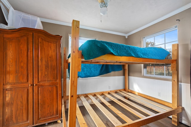 bedroom featuring hardwood / wood-style floors, crown molding, and ceiling fan