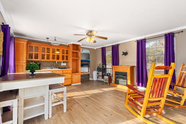 dining area featuring ornamental molding, light wood-type flooring, and ceiling fan