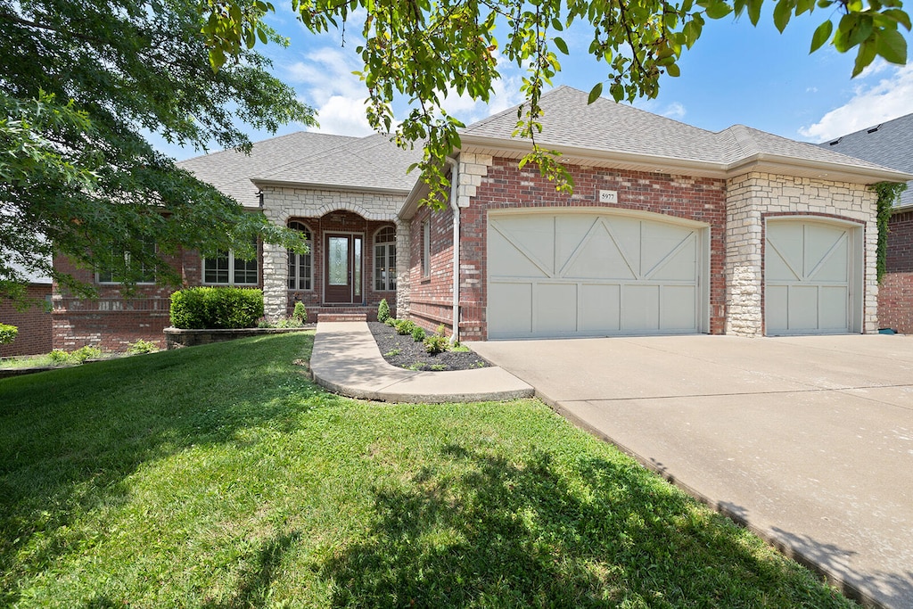 view of front of property featuring a front yard and a garage