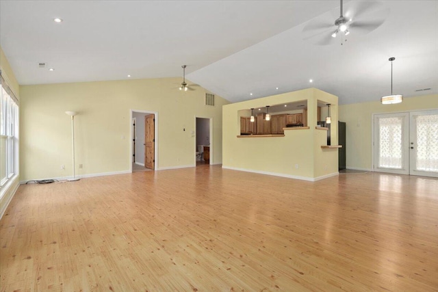 unfurnished living room featuring lofted ceiling, french doors, light wood-type flooring, and ceiling fan