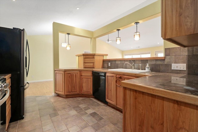 kitchen with tasteful backsplash, black appliances, sink, kitchen peninsula, and decorative light fixtures