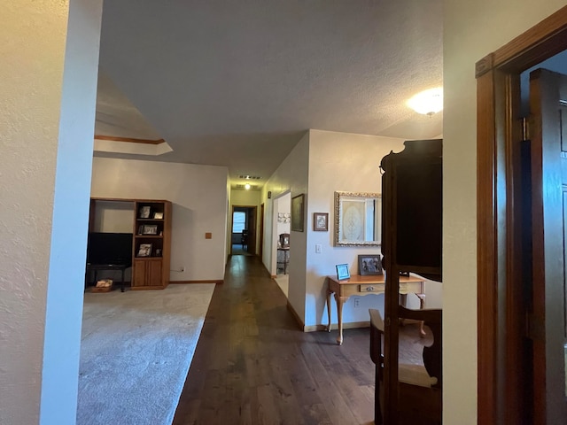 hall with wood-type flooring and a textured ceiling