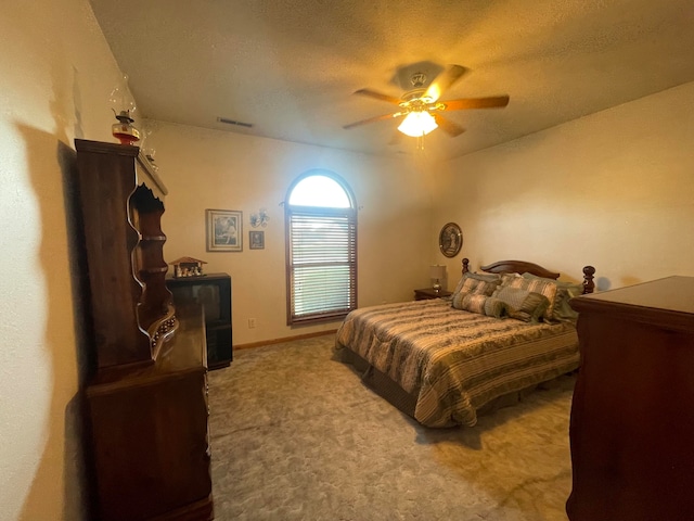 carpeted bedroom with a textured ceiling and ceiling fan