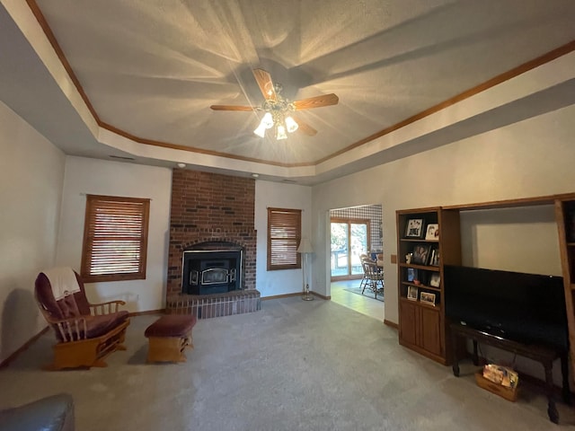 living room featuring ornamental molding, ceiling fan, carpet flooring, and a raised ceiling