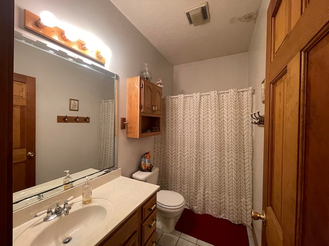 bathroom with a textured ceiling, toilet, walk in shower, vanity, and tile patterned flooring