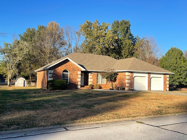 ranch-style home featuring a shed, a front yard, and a garage