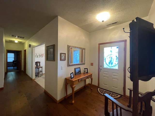 foyer featuring a textured ceiling and dark hardwood / wood-style flooring