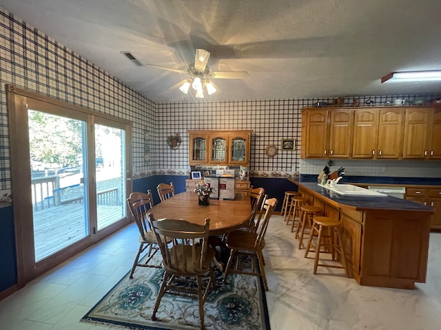 dining room featuring ceiling fan and a textured ceiling