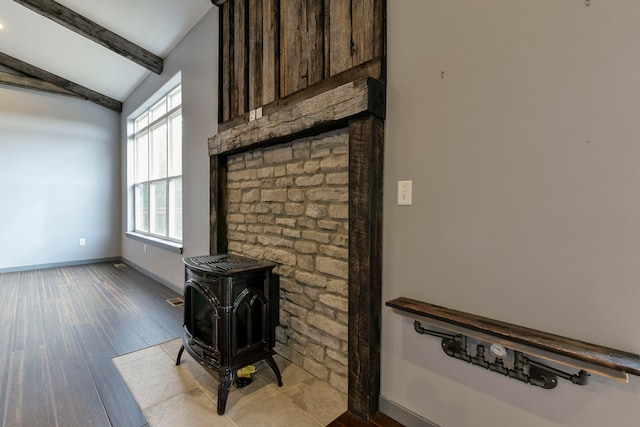 living room with lofted ceiling with beams, a wood stove, and light wood-type flooring