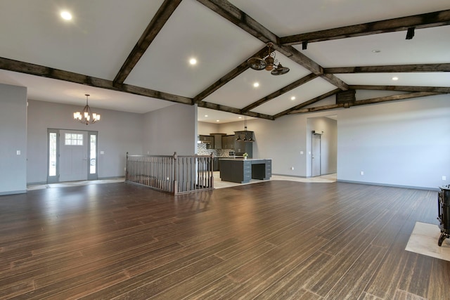 unfurnished living room featuring dark hardwood / wood-style flooring, vaulted ceiling with beams, and an inviting chandelier