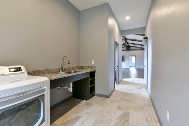 clothes washing area with washer / clothes dryer, sink, and light wood-type flooring