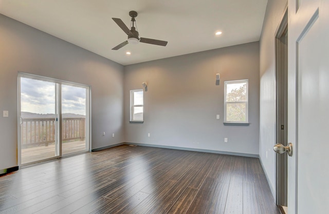 spare room with dark hardwood / wood-style floors, a healthy amount of sunlight, and ceiling fan