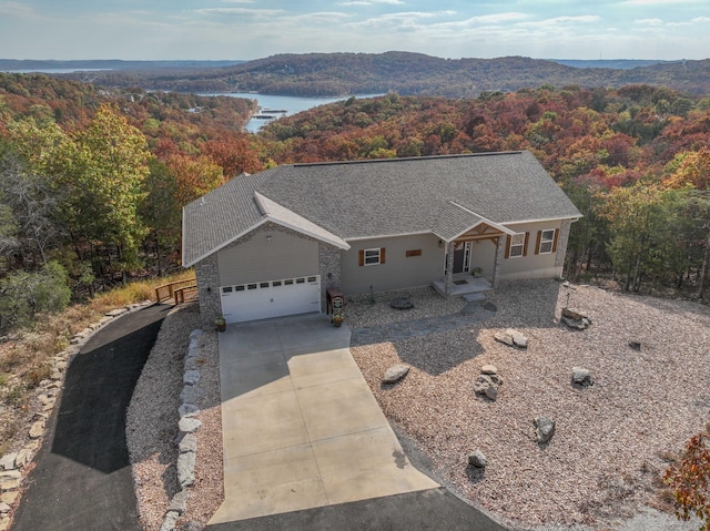 view of front of property with covered porch, a garage, and a water view