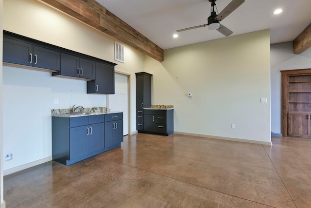 kitchen featuring beam ceiling, light stone counters, and ceiling fan