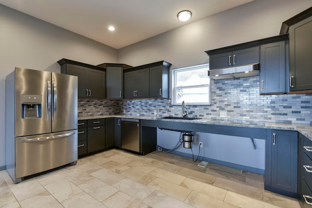 kitchen featuring sink, light stone countertops, stainless steel appliances, and tasteful backsplash