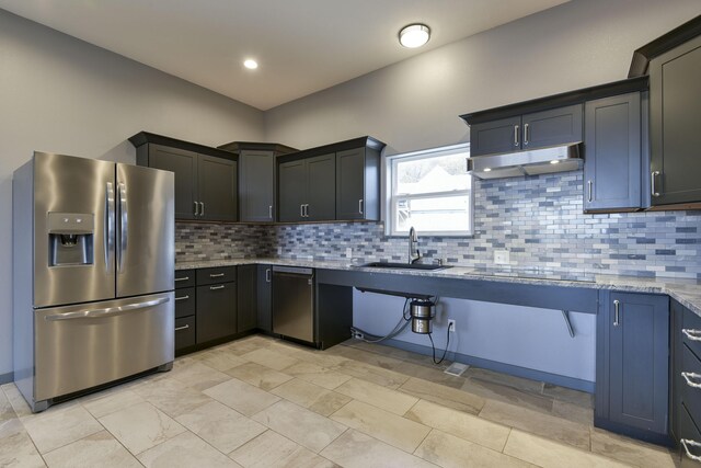 3133 Talking Rocks Rd, Reeds Spring, MO 65737 - kitchen with appliances with stainless steel finishes, under cabinet range hood, a sink, light stone counters, and tasteful backsplash
