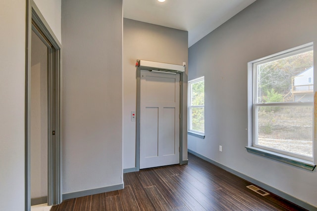 unfurnished bedroom featuring multiple windows and dark hardwood / wood-style flooring