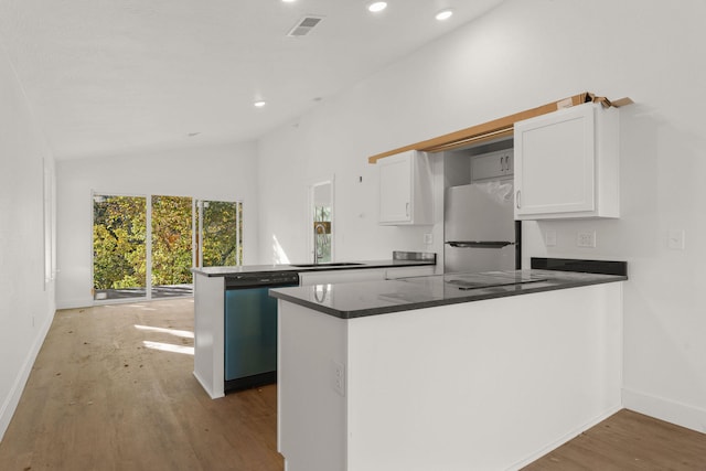 kitchen featuring kitchen peninsula, sink, vaulted ceiling, appliances with stainless steel finishes, and white cabinets