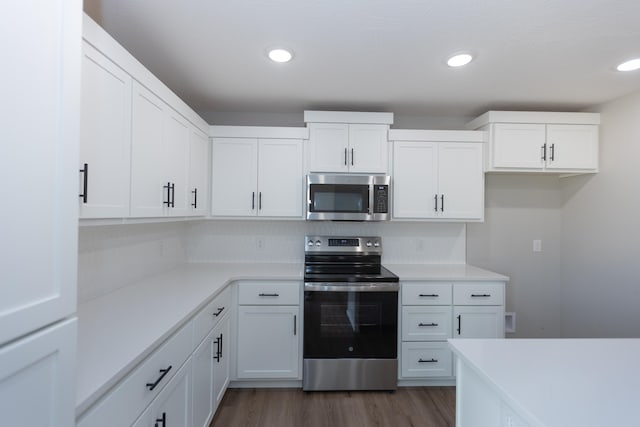 kitchen featuring dark wood-type flooring, appliances with stainless steel finishes, and white cabinets