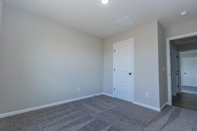 empty room featuring dark carpet