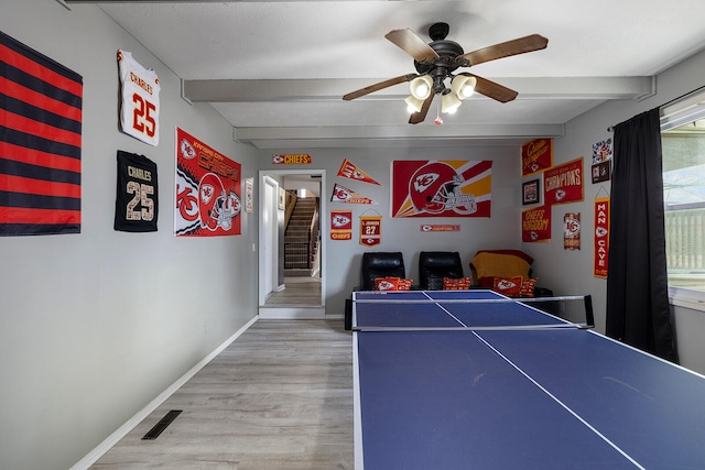 game room featuring hardwood / wood-style floors, beamed ceiling, and ceiling fan