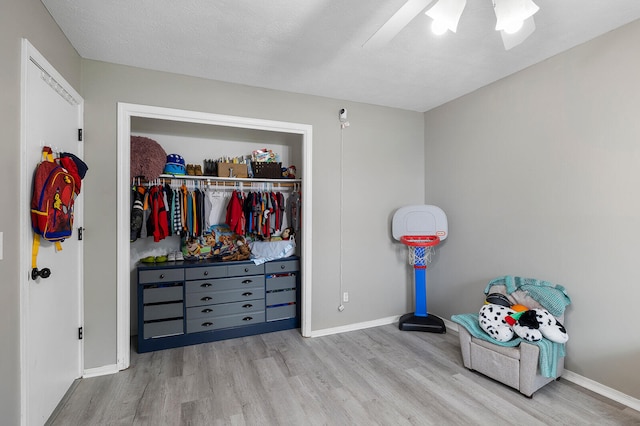 bedroom featuring a closet, ceiling fan, a textured ceiling, and light wood-type flooring