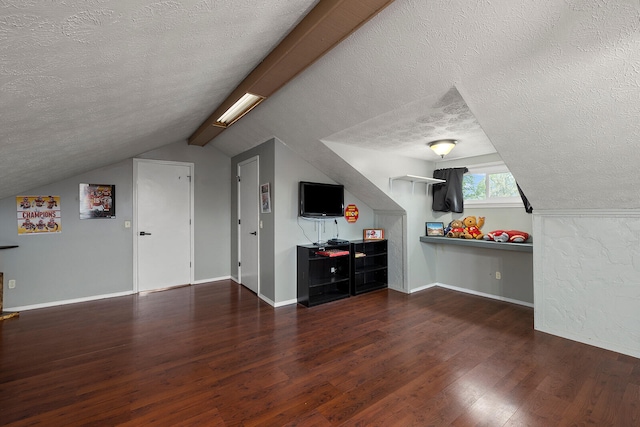 additional living space with vaulted ceiling with beams, a textured ceiling, and dark wood-type flooring