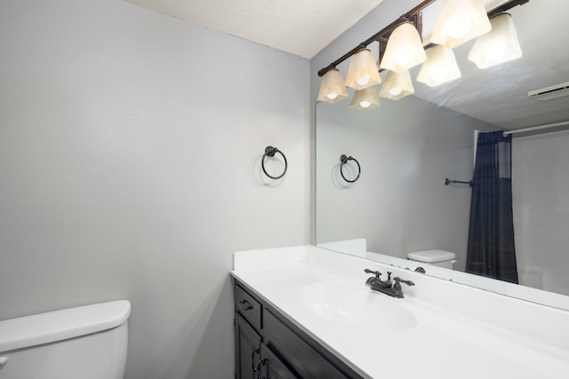 bathroom with vanity, toilet, a textured ceiling, and curtained shower